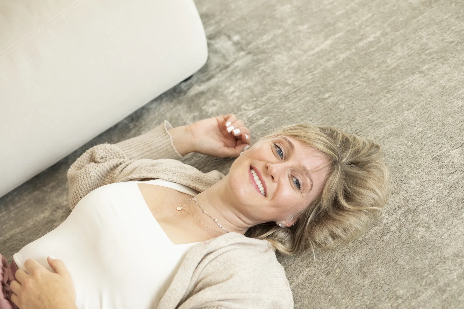 Frau liegt entspannt auf einem Sofa
